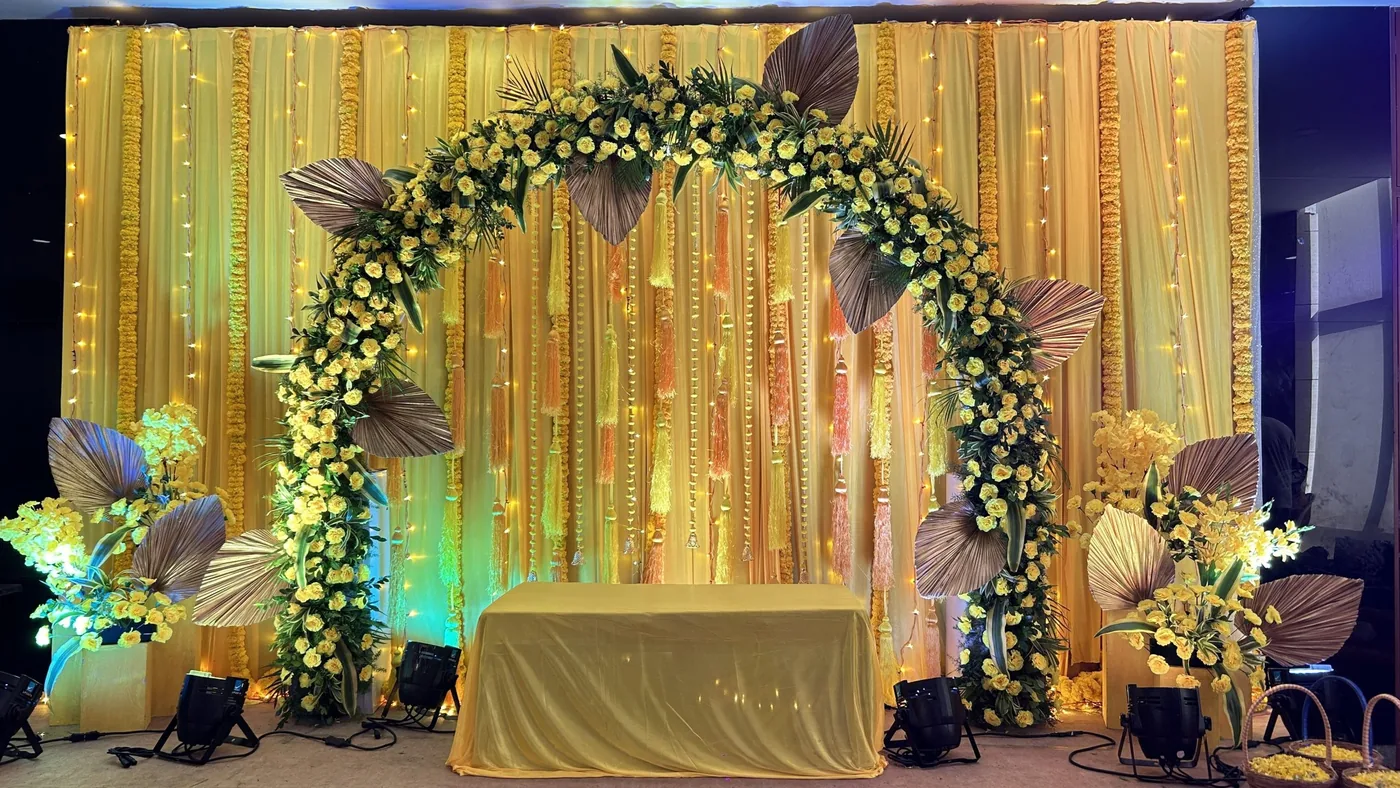Gold-lit backdrop with a white floral arch