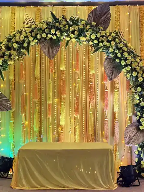 Gold-lit backdrop with a white floral arch