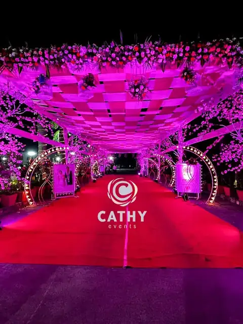 Pink and purple lit tunnel entrance over a red carpet